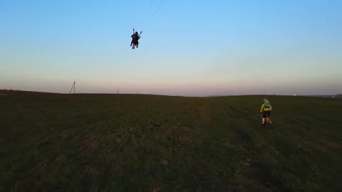 A paraglider is going to take off next to a motorcycle Stock Footage 196136388