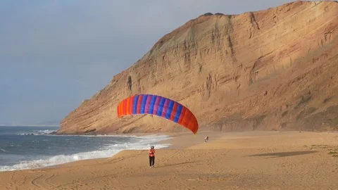 Paraglider Kiting Wing Up the Beach Distant Video stock 104872559