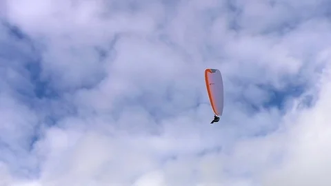 Paraglider makes a u-turn on background of the clouds and blue sky Stock Footage 73462742