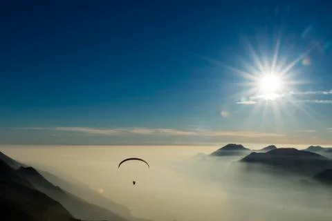 Paraglider over the mountains in clouds near Malcesine at Lake Garda aerial 스톡 사진