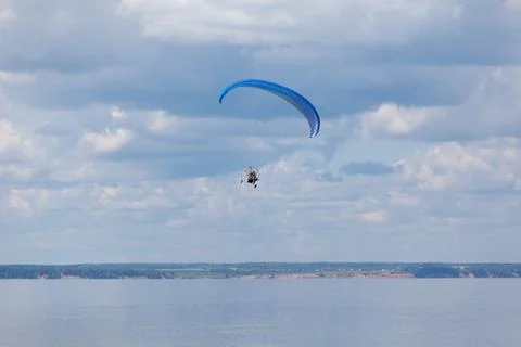 Paraglider over the river in the background of clouds Stock Photos