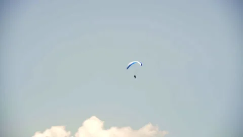 Paraglider performing acrobatic tricks, spirals, and twists high in the sky. Video stock 302881189