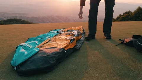 Paraglider pilot getting ready to fly by opening his wing. Video stock 266774315