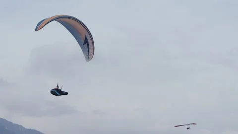 Paraglider pilot landing gracefully in cloudy sky 動画素材 321939165