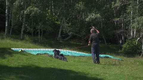 Paraglider Pilot Untangles Strings with Forest Backdrop Stock Footage 304676232