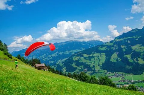 Paraglider preparing for flight on alpine meadows Stock Photos
