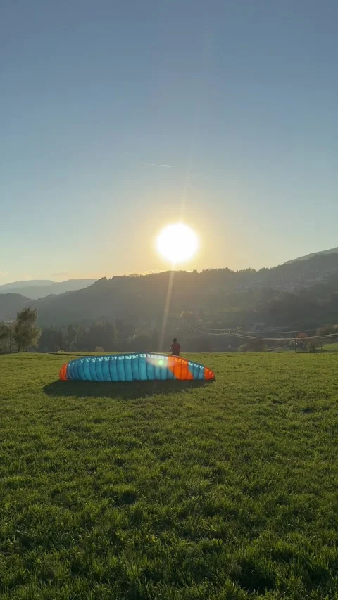 Paraglider Preparing on Grassy Ground in Sunlight Video stock 341057446