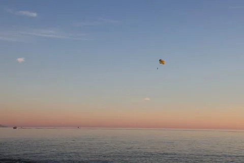 Paraglider in the sky in the rays of the setting sun, marine atmospheric back Stock Photos
