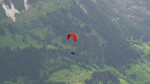Paraglider soaring above an alpine valley Stock Footage 79979169
