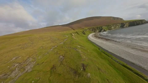 Paraglider soaring above the beautiful cliffs of Keel beach during sunset. Stock Footage 274178067