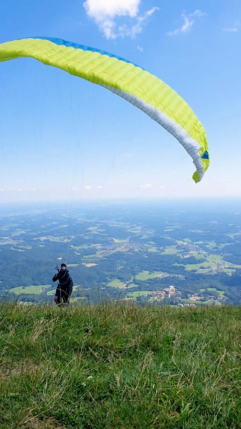 Paraglider Soaring Above Forest Under Blue Sky and White Clouds Over Mountains 스톡 동영상 331853859