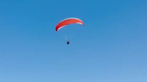 Paraglider soaring against clear blue skies. Stock Footage 312441156