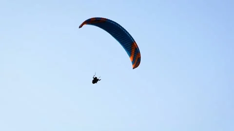 Paraglider soaring with the birds in the sky Stock Footage 202303693
