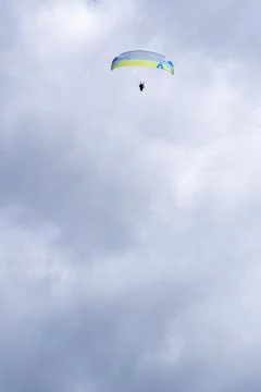 Paraglider soaring in cloudy sky with copy space 库存照片