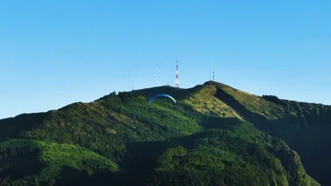 Paraglider soaring down Pico da Barrosa mountain in São Miguel, Azores. Aerial Stock Footage 300861888
