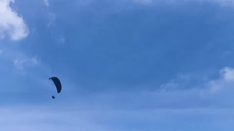 Paraglider Soaring High Across Clear Blue Sky With Soft White Clouds Video stock 342300695