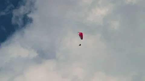 Paraglider soaring high in the deep cloud sky above majestic white clouds. Video stock 347660672