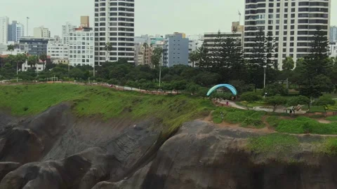 Paraglider soaring over cliffs in Miraflores with stunning city skyline in Stock Footage 313099888