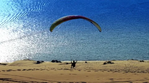 Paraglider soaring over a dune during sunset. Stock Footage 58728656