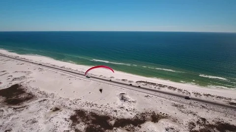 Paraglider soaring over sandy beach Stock Footage 72077932