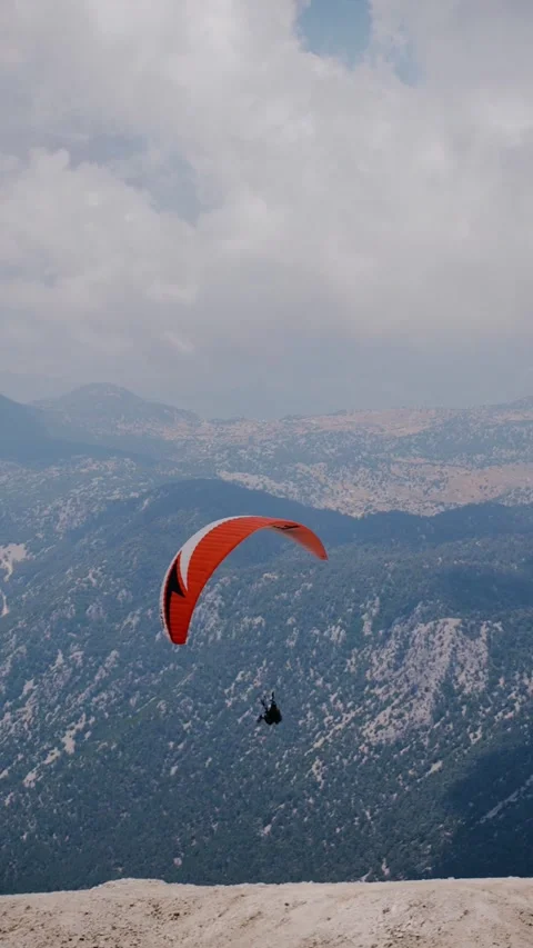 Paraglider Soaring Over Snow-Dusted Mountains Stock Footage 326723199