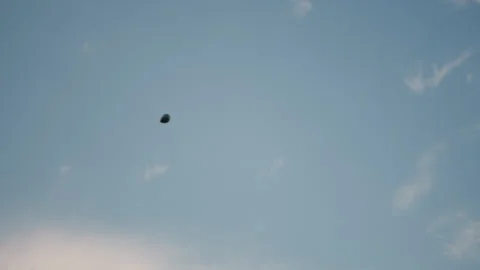 Paraglider soaring through sky surrounded by soft clouds under afternoon light Stock Footage 317147786