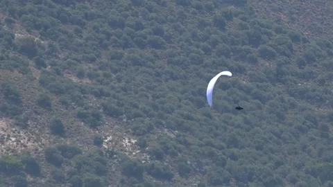Paraglider soars above open landscape, showing colorful outdoor adventure in Stock Footage 333849210
