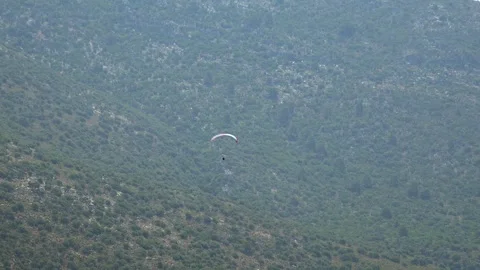 Paraglider soars above open landscape - Paragliding Adventure and Pilot Gliding Stock Footage 339820065