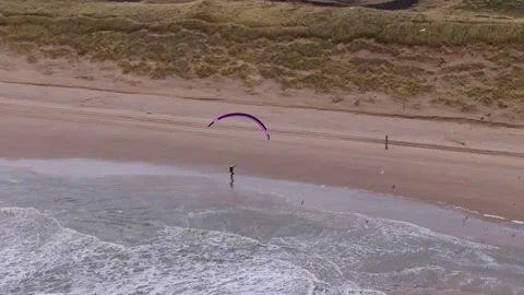 A paraglider soars along a serene beachscape under sunny skies Vídeo Stock 296794943