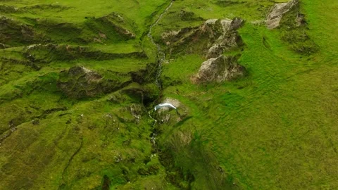 Paraglider soars over green mountain terrain and stream on Achill Island. Video stock 260887696