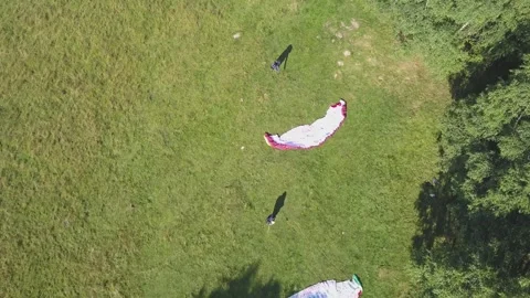 Paraglider standing on the side of a hill, waiting for the wind to Stock Footage 261504008