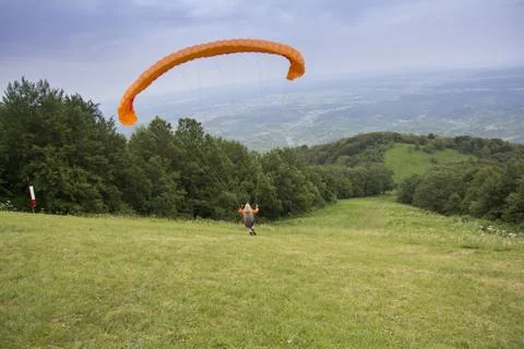 Paraglider taking off from the edge of the mountain Stock Photos