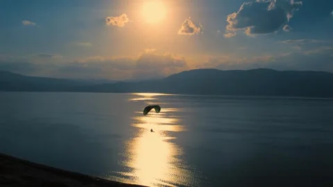 Paraglider Touching Water at Sunset Stock Footage 310751945