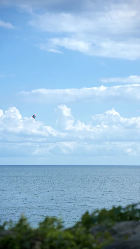 Paraglider trailing under blue sky and white clouds Stock Footage 343794434