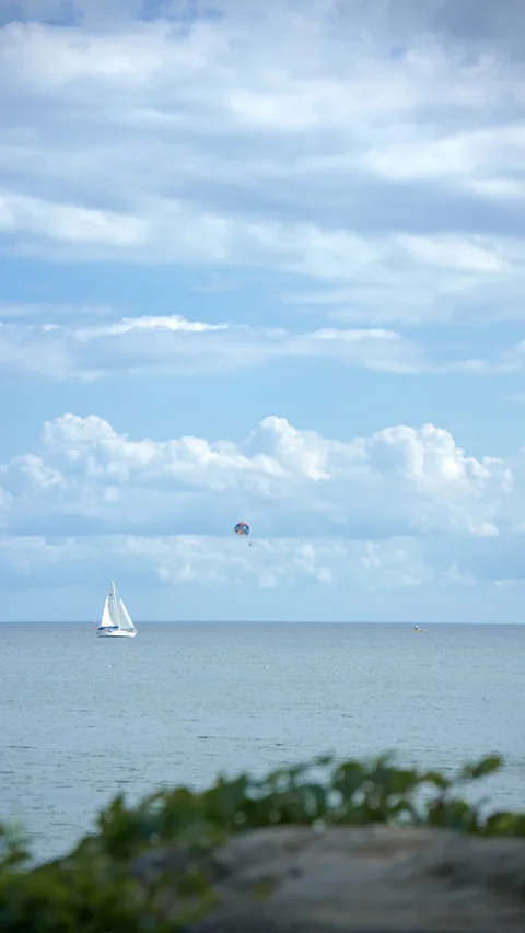 Paraglider trailing under blue sky and white clouds Stock Footage 343794445