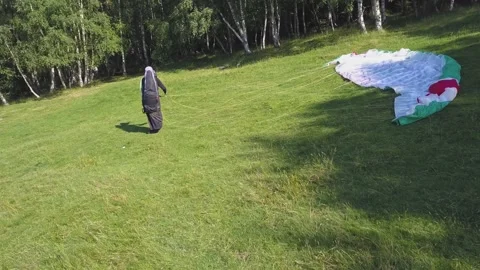 Paraglider untangles cord and getting ready to fly. Extreme sport of Stock Footage 261503200