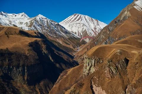 Paraglider with a wing on the background of high peaks of snowy mountains 写真素材
