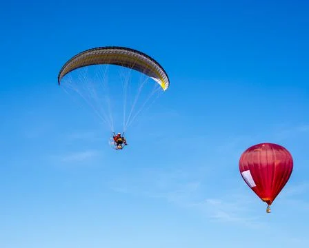 Paraglider withe red hot air balloon Stock Photos