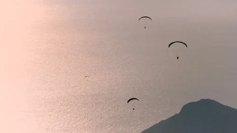 Paragliders drift across sunset sky above sea and islands near Fethiye Mugla Stock Footage 333870651