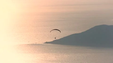 Paragliders drift across sunset sky above sea and islands near Fethiye Mugla Stock Footage 333872328