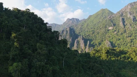 Paragliders fly in front of sun over Vang Vieng mountains in Laos during a sceni Vídeos de archivo 335311368