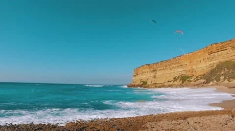 Paragliders Fly Over the Ocean Beach Stock Footage 61381591
