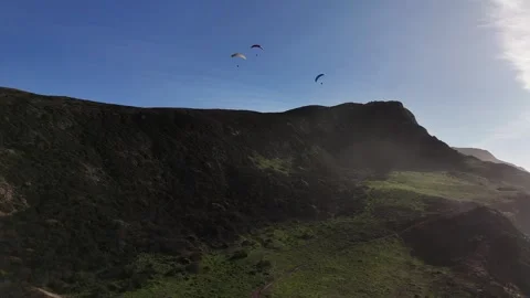 Paragliders flying in formation over cliff. Long Tracking drone shot Stock Footage 296209561
