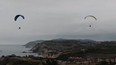 Paragliders flying over the coastal cliffs in Sopelana Stock Footage 342190609