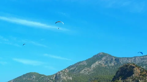 Paragliders gracefully soar through the sky. Stockbeeldmateriaal 327901434