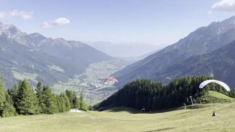 Paragliders launch from an alpine meadow below Elfer mountain into the Video stock 319053313