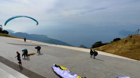Paragliders preparing and taking off from Babadag mountain launch site Stock Footage 334008618