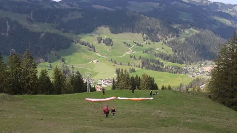 Paragliders preparing on the top of the mountain Stock Footage 274974801