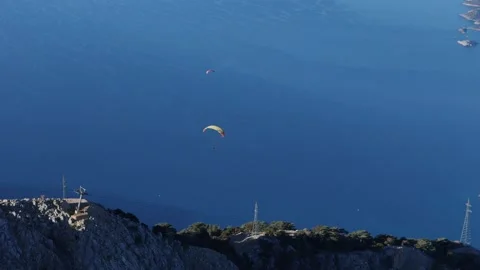 Paragliders soaring over a deep blue sea near Turkish mountains Video stock 315371106