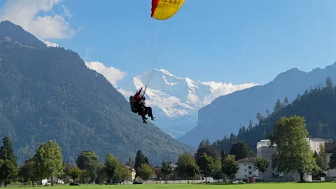 Paragliders soaring over the Höhematte in Interlaken with Jungfrau mountain 動画素材 325860432